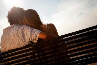 Loving couple sitting on a bench enjoying the sun