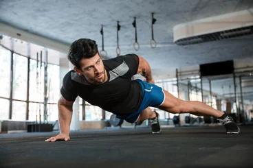 Portrait of a handsome man doing push ups exercise with one hand in fitness gym-1